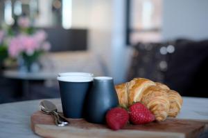 a tray with croissants and strawberries on a table at The KC Elizabeth Bay in Sydney