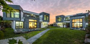 a large house with a lawn in front of it at Happiness Pension in Jeju