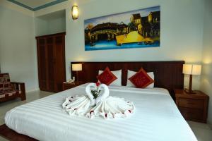 Säng eller sängar i ett rum på Hoi An Holiday Villa