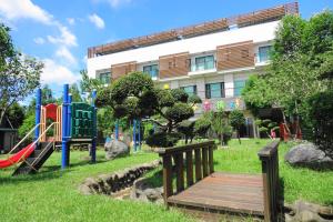 un parque con un puente de madera y un parque infantil en One City One Vacation Farm en Nantou City