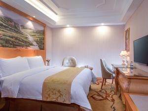 a hotel room with a bed and a desk and a computer at Vienna International Hotel Puning International Commodity City in Puning +9 photos