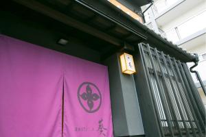 a purple banner on a wall with a clock on it at Hosta Nijo Aoi in Kyoto
