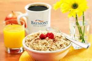 a bowl of oatmeal with strawberries and a cup of coffee at Baymont by Wyndham Norcross Atlanta in Norcross