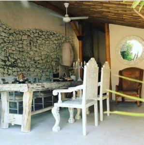 a dining room with a table and two white chairs at Gravity Eco Boutique Hotel - Adults Only in Uluwatu