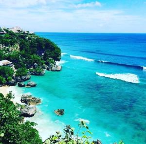 a view of a beach with blue water and rocks at Gravity Eco Boutique Hotel - Adults Only in Uluwatu