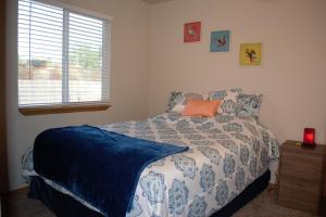 Schlafzimmer mit einem Bett mit einer blauen und weißen Bettdecke in der Unterkunft 8635 Ustick Road Apartment in Boise
