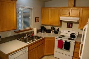 eine Küche mit Holzschränken und einem weißen Herd mit Backofen in der Unterkunft 8635 Ustick Road Apartment in Boise