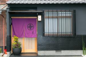 ein lila Banner an der Tür eines Gebäudes in der Unterkunft Hosta Nijo Aoi in Kyoto