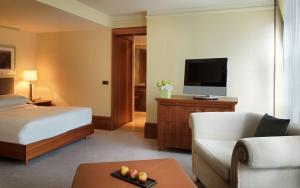 a hotel room with two beds and a television at Park Hyatt Hamburg in Hamburg