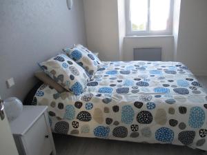 uma cama com um edredão e almofadas azuis e brancas em Appartement Clémenceau em Saint Malo