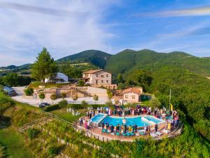 un gran grupo de personas de pie alrededor de una piscina en La Castellaia Resort, en Fabriano