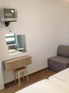 a bedroom with a desk and a tv on a wall at Aggeliki-Smaro Studios in Neos Pirgos