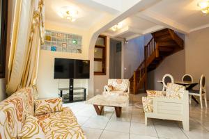 a living room with two couches and a tv at OCEANIS HOME & VOYAGES - Navette incluse en aller simple in Ivato