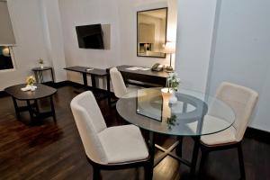a dining room with a glass table and chairs at Samala Hotel Jakarta Cengkareng in Jakarta