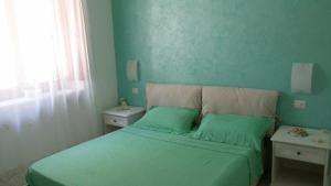 a green bedroom with a bed with two night stands at Acquamarina Accommodation in Massa Lubrense