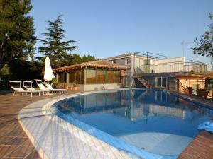 - une piscine avec des chaises et une maison dans l'établissement Valle Degli Ulivi, à Motta SantʼAnastasia