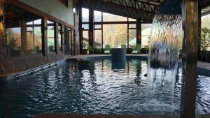 a fountain in the middle of a swimming pool at Cabañas Blanche Neige Wellness & SPA in Las Trancas
