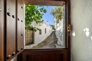 an open door with a view of an alley at Casa La Fragua in Capileira