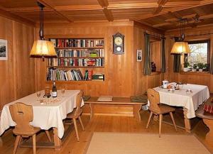 een eetkamer met 2 tafels en een boekenplank bij Gasthof Zur Sonne in Laion