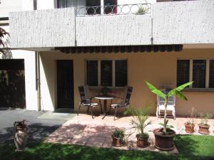 un patio con mesa, sillas y plantas en Ferienwohnung Frei, en Bad Ragaz