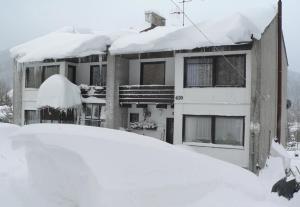 a snow covered house with a pile of snow at Konvalinka - ubytování v soukromí in Harrachov