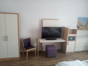 ヴィルヘルムスハーフェンにあるFerienwohnung Johannaのベッドルーム(デスク、テレビ、椅子付)