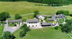 eine Luftansicht eines großen Hauses auf einem grünen Feld in der Unterkunft Le Hameau de Barboron in Savigny-lès-Beaune