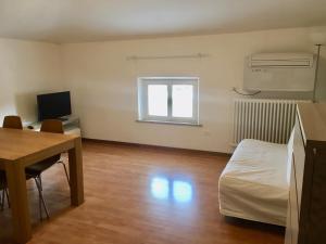 a room with a desk and a bed and a table at Riva San Vito 2 in Grado