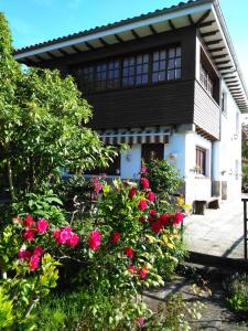 una casa con rosas rosas delante de ella en Casa Tirador en San Martin del Mar