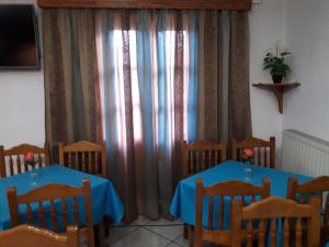 Effie Hotel في سكالا: غرفة طعام مع طاولتين وكراسي وستائر