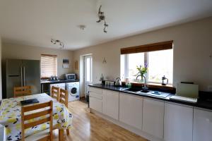 a kitchen with white cabinets and a counter top at Hillside in Dunvegan