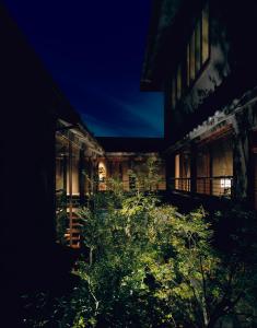 uma casa à noite com um jardim em frente em Yuzuya Ryokan em Quioto