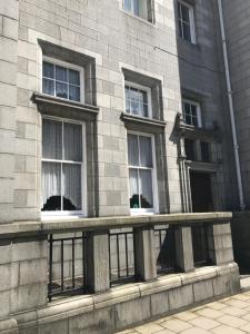 a building with three windows on the side of it at City Centre Executive Apartment - Private Parking, Gym & Sauna in Aberdeen