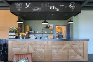 a restaurant with a large wooden counter with a bar at Hotel Chalets Middelburg in Middelburg