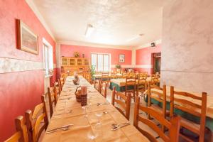 Albergo Belvedere في كوليو: غرفة طعام مع طاولة وكراسي طويلة