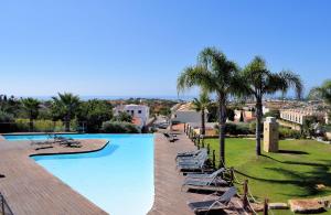 una gran piscina con tumbonas y palmeras en Luxury Villa Albufeira, en Albufeira