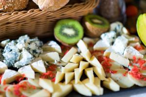 a basket full of cheese and vegetables and bread at Alexandra Golden Boutique Hotel-Adults Only in Chrysi Ammoudia