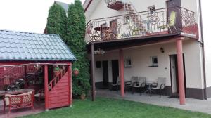a building with a balcony and a table and chairs at Pensjonat Basia in Mielno