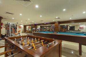 a fitness room with pool tables and exercise equipment at Al Bustan Hotel Suites in Al Hofuf