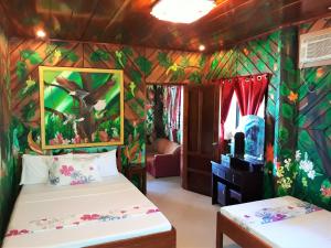 a bedroom with two beds in a room with colorful walls at Ausan Beach Front Cottages in San Vicente