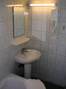 ein Badezimmer mit einem Waschbecken, einem Spiegel und einer Badewanne in der Unterkunft Le Soleil in Wildenstein