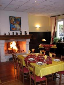 una sala da pranzo con tavolo e camino di Le Soleil a Wildenstein