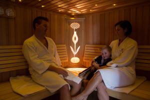 two women and a baby sitting in a sauna at Arkadenhof Flasch in Wörterberg