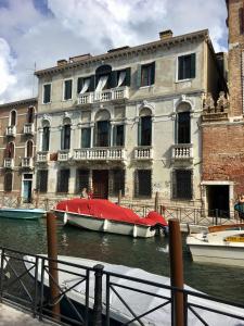 a boat in the water in front of a building at La Chambre D'Ella in Venice