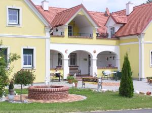 a yellow house with a fountain in the yard at Arkadenhof Flasch in Wörterberg