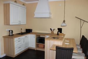 a kitchen with white cabinets and a wooden counter top at Ferienwohnung Westwind in Schüller