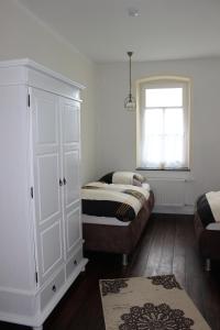 - une chambre avec un lit, une armoire et une fenêtre dans l'établissement Ferienwohnung Westwind, à Schüller