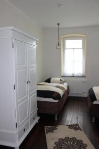 a bedroom with a bed and a cabinet and a window at Ferienwohnung Westwind in Schüller