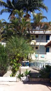 a resort with palm trees and a building at HOTEL pousada CASARÃO in Serra Negra