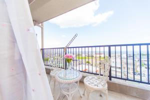 a balcony with chairs and a table with flowers on it at Awaji Central Room NC03 in Awaji